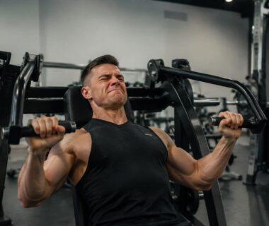 Lifter completing a challenging final chest press repetition with controlled machine resistance