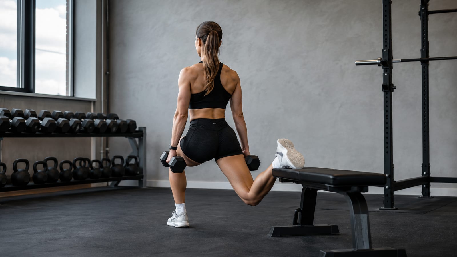 Athlete completing supported split squats with dumbbells to strengthen each leg independently