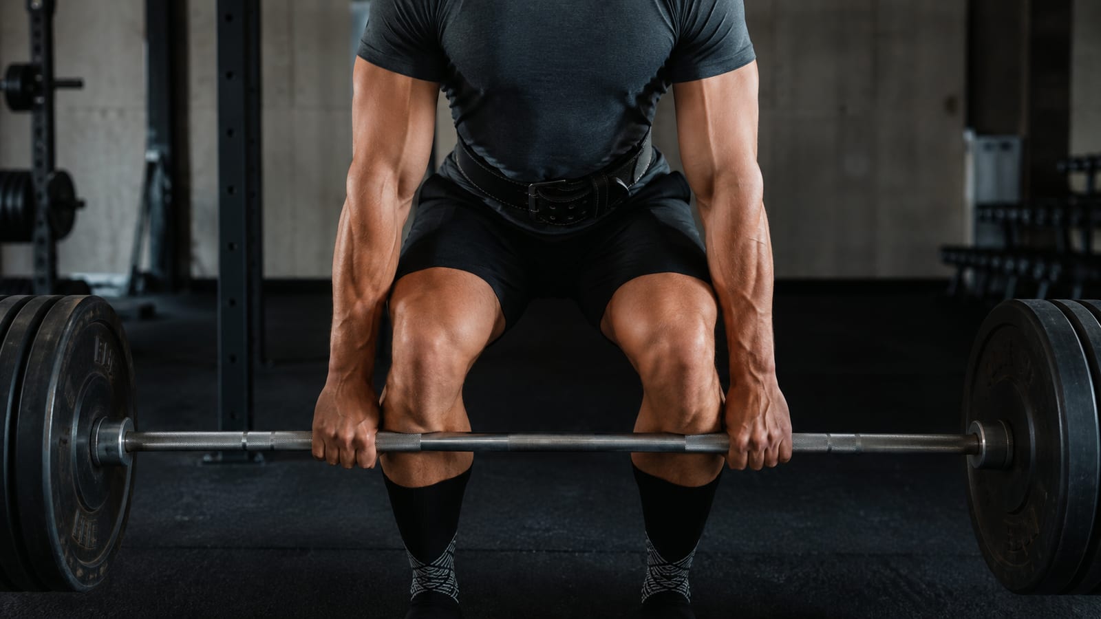 Athlete practicing symmetrical barbell deadlift technique with carefully aligned hips and shoulders