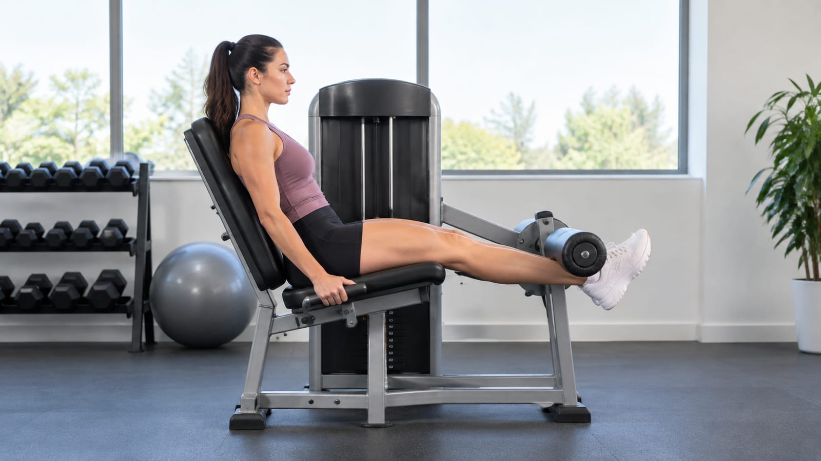 Athlete using a leg extension machine with controlled tempo and stable seated posture