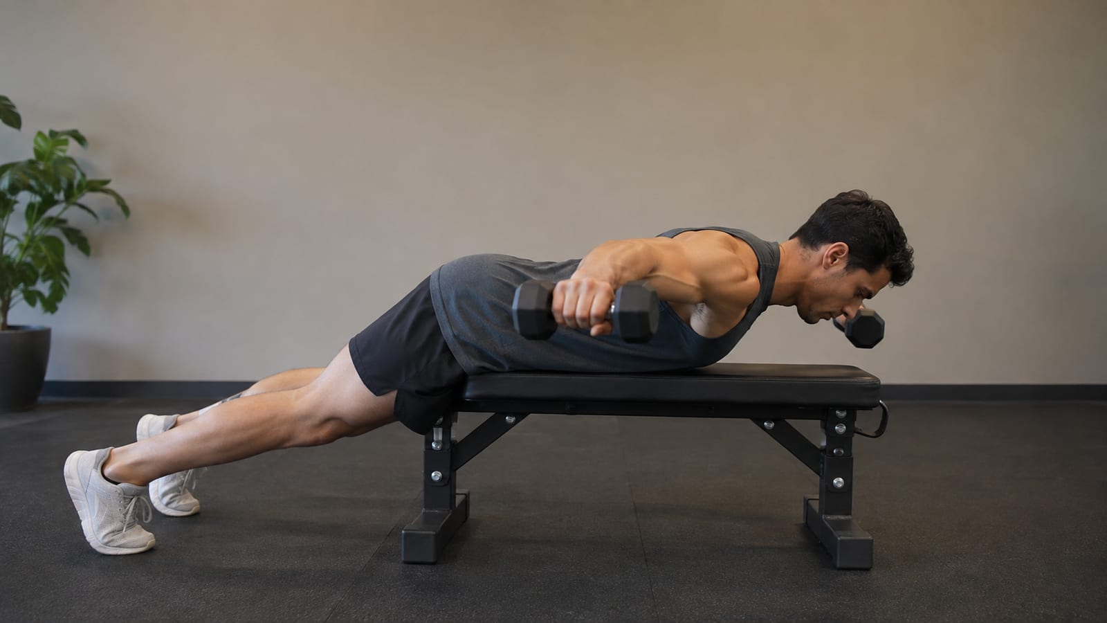 Lifter demonstrating strict rear-delt fly form with dumbbells, neutral spine, and controlled movement