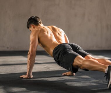Athlete performing a controlled scapular push-up in a bright strength-training gym