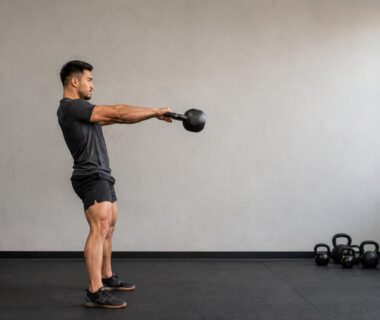 Athlete performing a powerful kettlebell swing during a high intensity full body workout