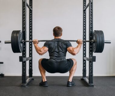 Athlete performing a heavy barbell squat in a well-equipped strength training gym