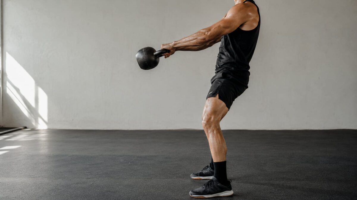 Athlete swinging a kettlebell hard during high intensity training