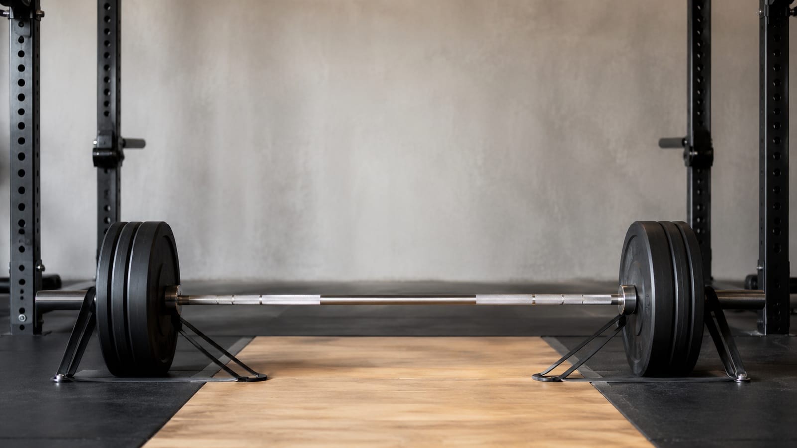 Barbell deadlift setup with resistance bands anchored under the bar