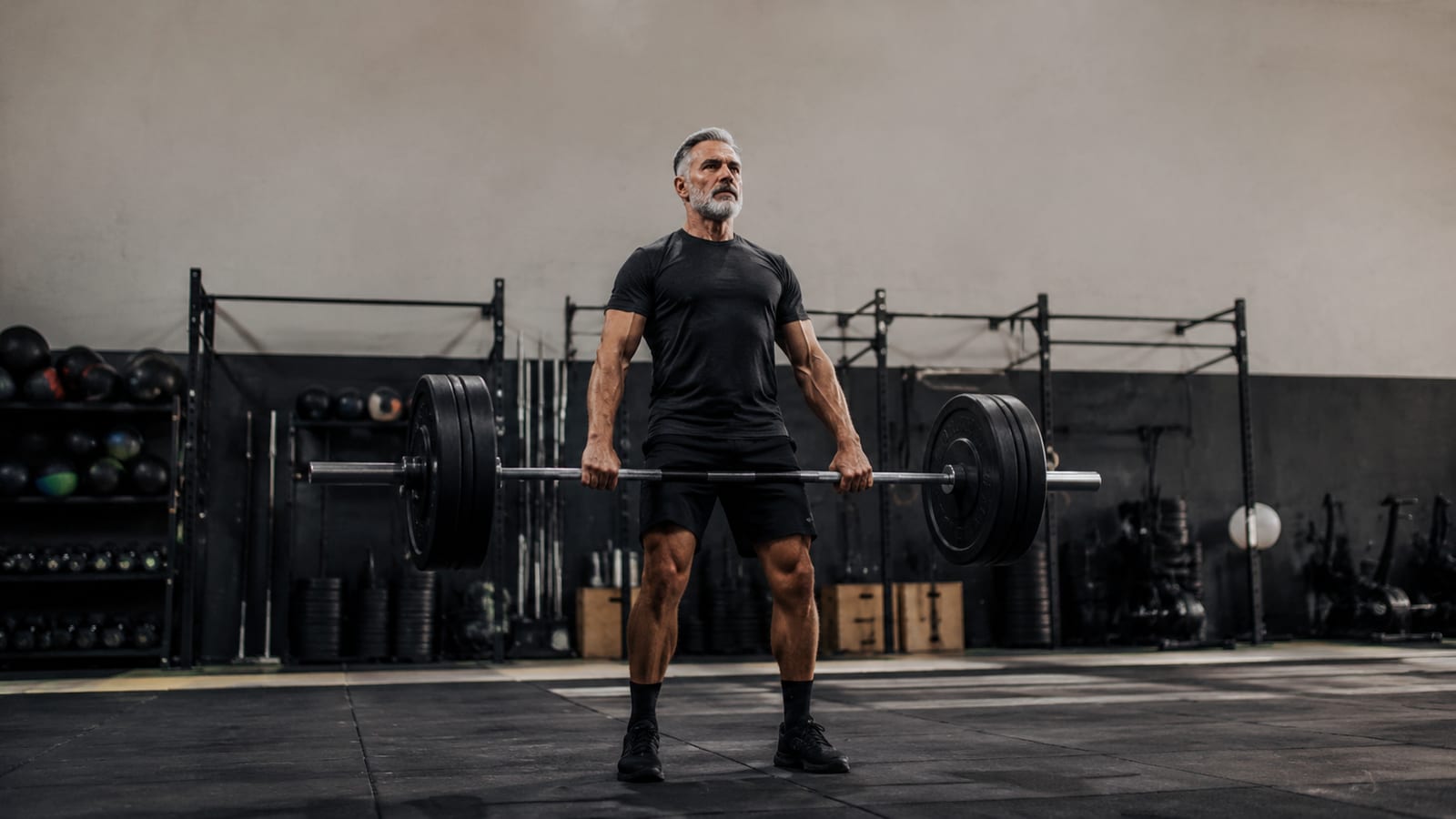 Athlete progressing through structured strength training with barbells and conditioning equipment