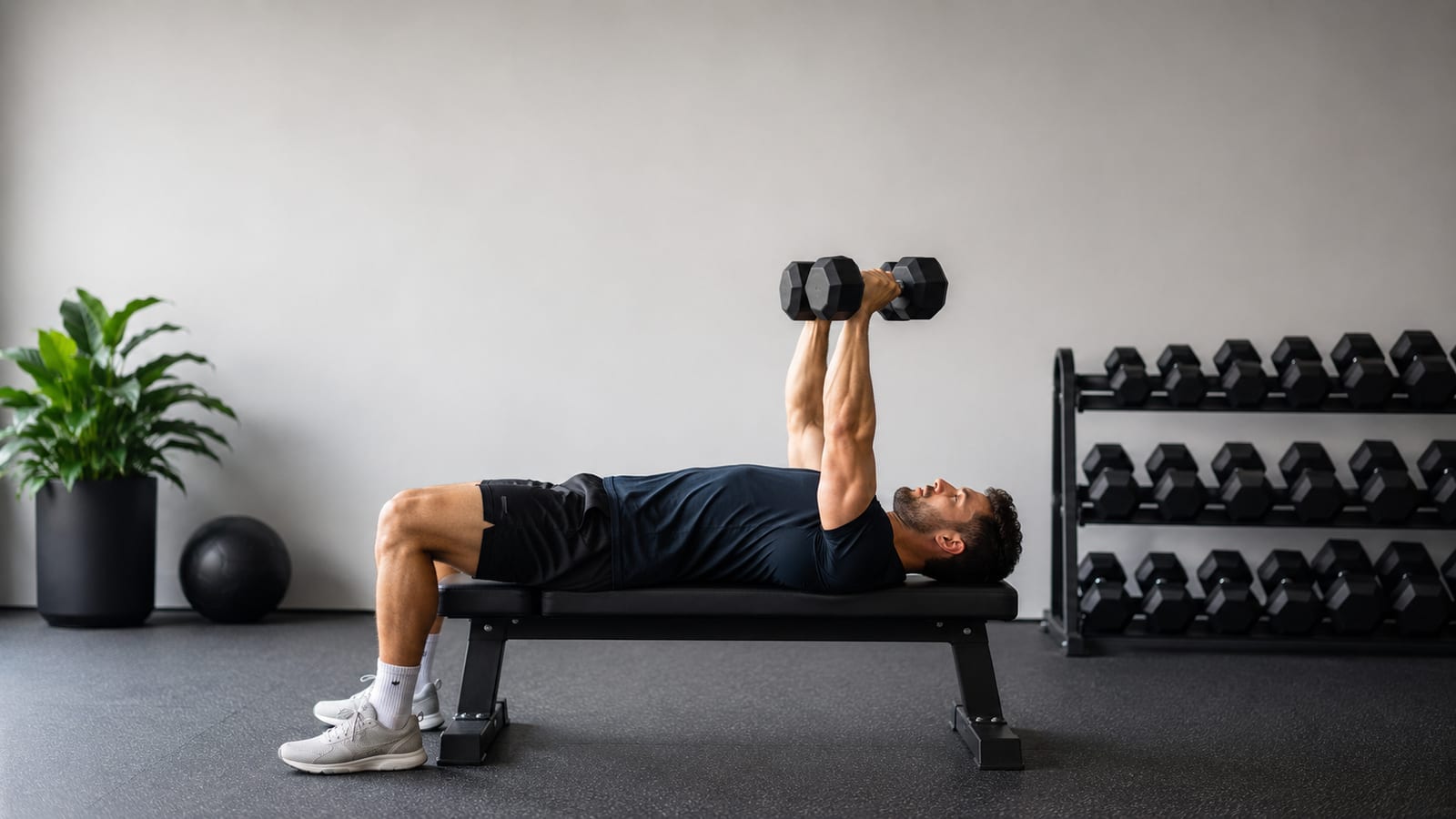 Athlete performing dumbbell bench press during an efficient full-body strength workout